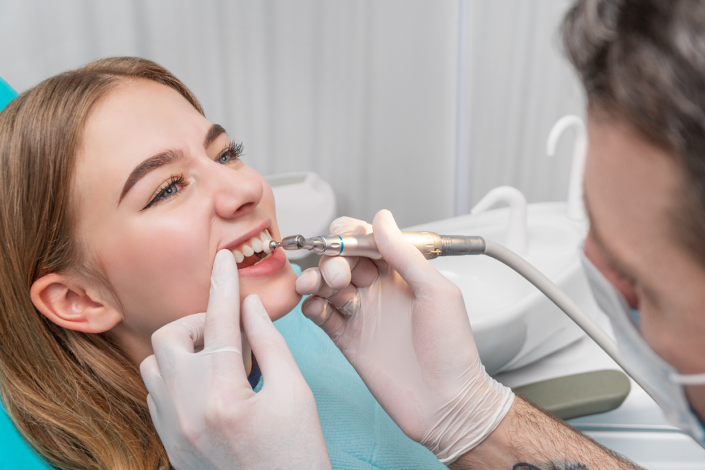 A dentist is performing a teeth cleaning on her patient